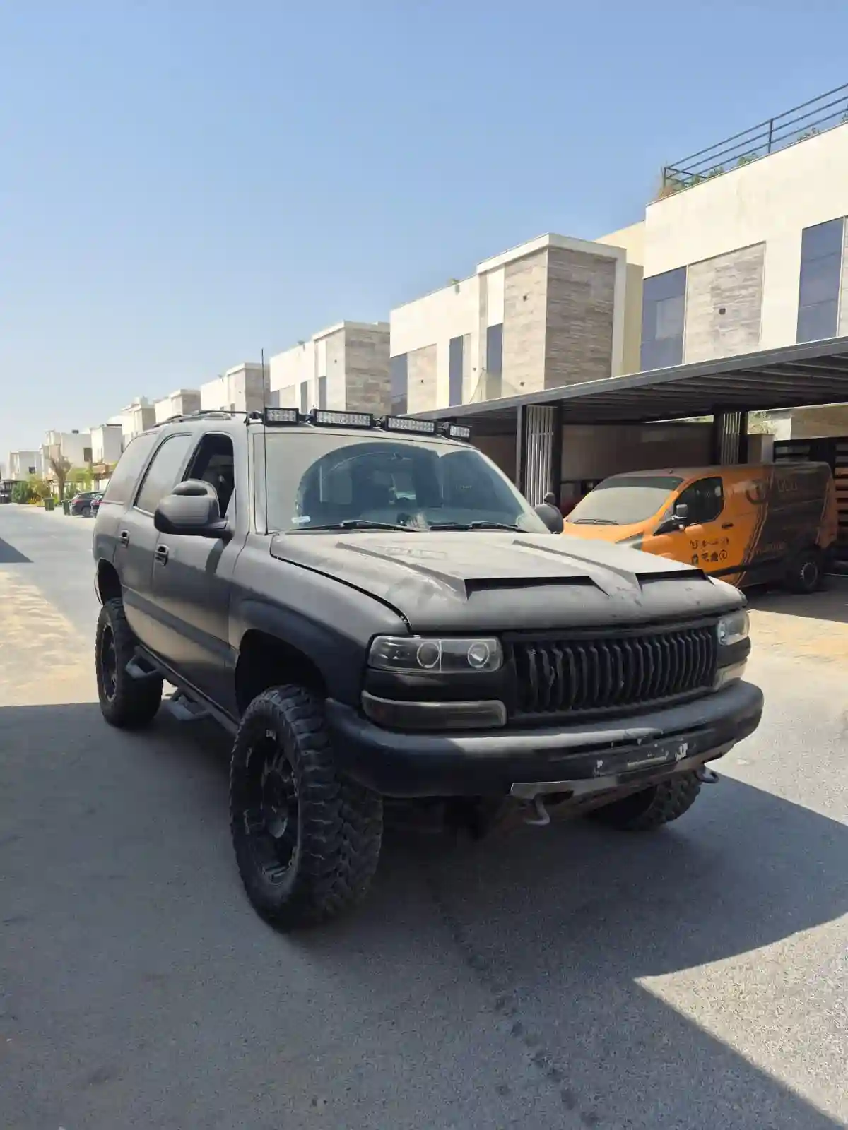 Matte black Chevrolet Tahoe SUV parked on a residential street for scrap vehicle evaluation